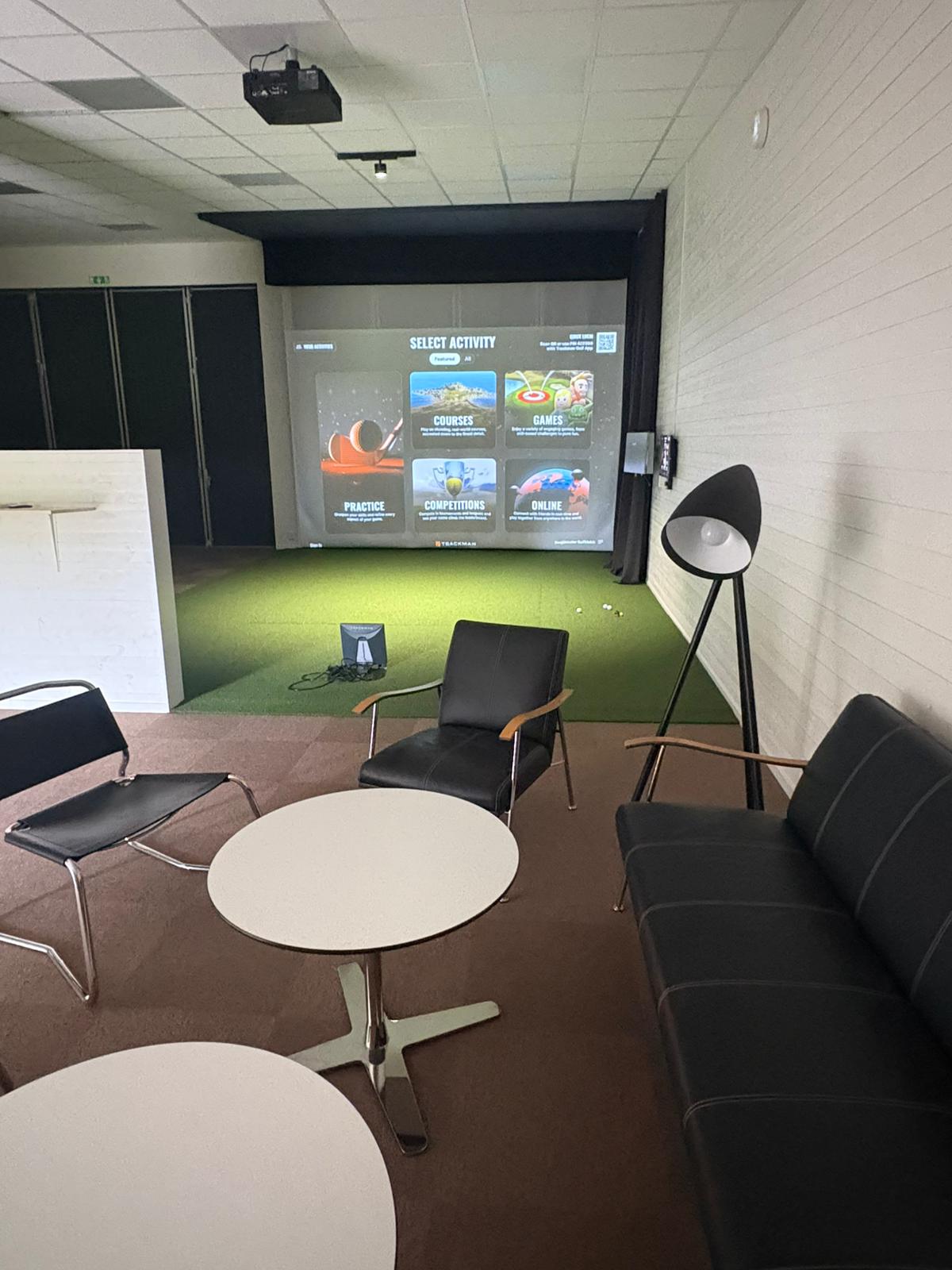 Interiör från Bosjöklosters golfstudio med simulator och sittplatser